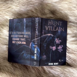 K&ouml;nnte beinhalten: Ein Buch mit dem Titel "Hunt the Villain" von Rina Kent. Das Cover zeigt eine dunkle Illustration von zwei M&auml;nnern in einem Wald. Der Titel und der Name des Autors sind zu sehen, sowie das Zitat: "He's so fucking mine, and nothing will change that. Not even him."