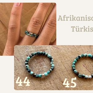 May include: Two beaded rings made of small, faceted African turquoise stones. Ring 44 features a gold-toned bead, while ring 45 includes a silver-toned bead. The text Afrikanischer T&uuml;rkis is visible, along with the numbers 44 and 45.