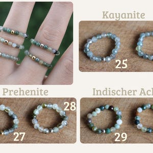 May include: A collection of beaded rings featuring faceted gemstones in shades of green, blue, and earth tones. Each ring includes a single metallic accent bead. The image displays rings labeled 25 through 30, categorized as Kayanite, Prehenite, and Indischer Achat.