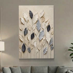 May include: A rectangular wall art piece featuring a textured beige background with a vertical arrangement of raised, three-dimensional leaf shapes in shades of cream, light gray, dark gray, and black, each connected by thin, dark vertical stems.