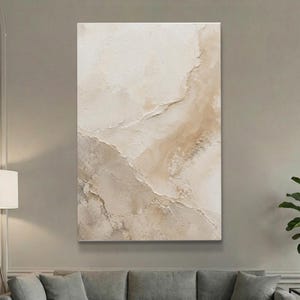 May include: A vertical rectangular canvas painting featuring a textured, abstract composition in shades of cream, beige, and light tan. The surface displays layered, raised paint strokes creating a topographical, stone-like appearance with soft gradients.