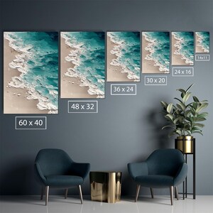 May include: A set of five canvas wall art pieces depicting an abstract ocean scene. The artwork features textured white waves crashing onto a beige sandy shore, with turquoise water. The sizes are 60 x 40 inches, 48 x 32 inches, 36 x 24 inches, 30 x 20 inches, and 24 x 16 inches, and 14 x 11 inches.