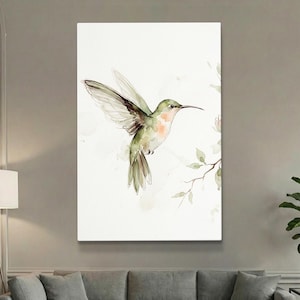 May include: Watercolor painting of a hummingbird in flight. The bird has green and peach-colored plumage with outstretched wings. A branch with leaves and small pink flowers is to the right, set against a white background.