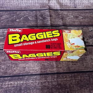 Puede incluir: Una caja roja de bolsas Hefty Baggies para almacenamiento pequeño y sándwiches. La caja tiene texto amarillo que dice "BAGGIES" y "bolsas pequeñas de almacenamiento y sándwich". Contiene 80 bolsas de plástico, cada una de 15,88 cm x 20,32 cm, con 80 lazos de torsión.