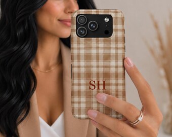 May include: A tan and white plaid phone case featuring the dark brown monogram letters SH centered on the back. The case has a rectangular cutout for the camera lenses and a circular cutout for the flash, matching a modern smartphone design.