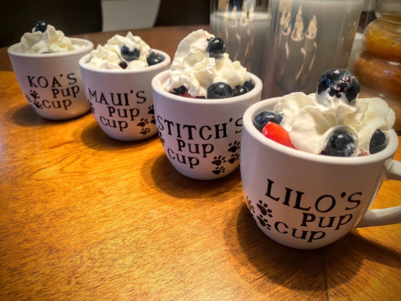 White Personalized Pup Cups with black letters filled with whipped cream and fruit