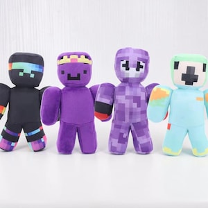 May include: Four plush figures in various colors. The figures have blocky heads and bodies, with pixelated details. Colors include black, purple, and light blue, with accents of rainbow, red, and yellow. The figures are standing upright.