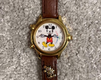 Reloj de pulsera vintage Lorus Mickey Mouse con alarma y sonido V69F-6000, de cuero marrón y detalles dorados.