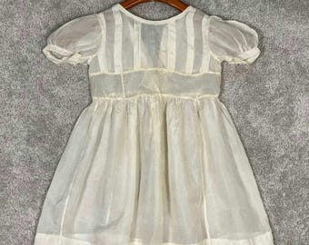 Abito da bambina edoardiano in cotone bianco, maniche a sbuffo, abbottonatura posteriore, vita impero.