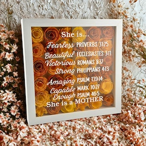 May include: A white ceramic mug with a black handle and the text "But First, Coffee" in a black, handwritten-style font. The mug is on a white surface.