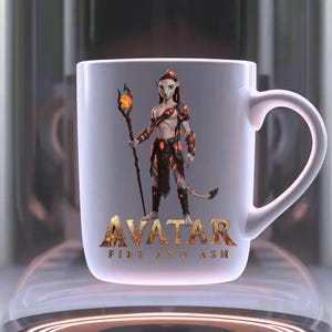 May include: White ceramic mug featuring a character from Avatar: Fire and Ash. The character is depicted with orange and black armor and holding a staff with a glowing orb. The mug has the word "AVATAR" and the phrase "FIRE AND ASH" printed on it.