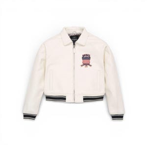 Puede incluir: Chaqueta bomber color crema con cuello y cierre de cremallera. La chaqueta presenta un parche con un dise&ntilde;o de bandera americana y el nombre de la marca. Los pu&ntilde;os y el dobladillo tienen detalles a rayas blancas y negras.