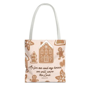 Puede incluir: Un bolso de mano con un fondo rosa claro con galletas de jengibre y el texto "As for me and my house, we will serve the Lord. Joshua 24:15." El bolso tiene un asa blanca.