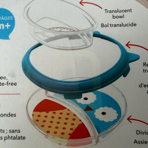 May include: A clear, divided baby bowl with a blue rim and a translucent lid. The bowl features a section with a red and tan polka-dot pattern and a section with a blue owl design. The text "Translucent bowl" is visible.