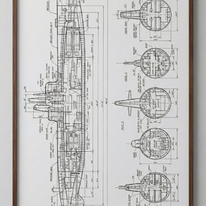Pode incluir: Planta em preto e branco emoldurada de um submarino, mostrando esquemas detalhados e cortes transversais. A impressão inclui medidas em centímetros e anotações técnicas, oferecendo um olhar aprofundado sobre o design da embarcação.