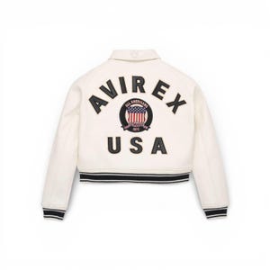May include: Cream-coloured bomber jacket with black and white striped trim. The back features the word "AVIREX" above a circular emblem with the words "ALL AMERICANS" and "USA". The emblem includes the American flag.