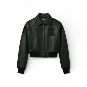 May include: Black leather bomber jacket with a zip-up front, collar, and ribbed cuffs and hem. Features a small patch on the chest and the brand name on the collar. A classic outerwear piece.