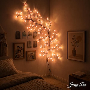 Pode incluir: Uma luz decorativa de parede em forma de ramo com numerosas pequenas lâmpadas brilhantes em forma de flor rosa. O ramo escuro e fino estende-se vertical e horizontalmente pelo canto da sala, emitindo uma luz ambiente quente e suave.