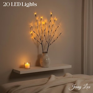 May include: A white ceramic mug with a black handle and the text "But First, Coffee" in a handwritten style. The mug is on a white surface. The mug is approximately 4 inches tall.