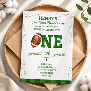 Könnte beinhalten: Eine Einladung zum Thema Football mit dem Text "HENRY'S First Year TouchDown". Die Einladung zeigt eine braune Football-Grafik, das Wort "ONE" in Grün und das Datum 28. November. Enthält Eventdetails und RSVP-Informationen.