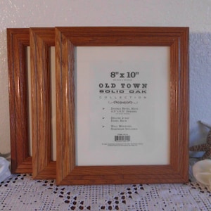 May include: Three 8x10 inch solid oak picture frames in a natural wood finish. The frames have a double bevel mat and a deluxe 2-way easel back. The frames are part of the Old Town Collection.