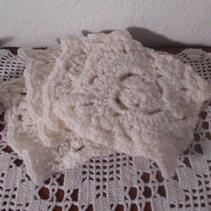 May include: Three white crocheted doilies with a delicate floral pattern.