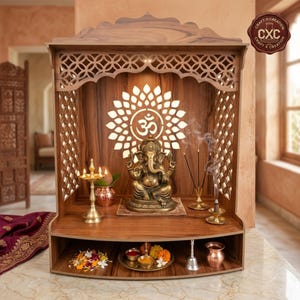 Può includere: Un tempio domestico in legno con un pannello posteriore tagliato al laser che presenta un simbolo Om e un motivo floreale. All'interno si trovano una statua di Ganesha in ottone, una lampada a olio e incenso. Il ripiano inferiore contiene una campana.