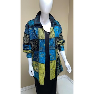 May include: A patchwork jacket in shades of blue, black, and chartreuse green. The jacket features a collared neckline, long sleeves, and a button-down front. The fabric has a patterned design.