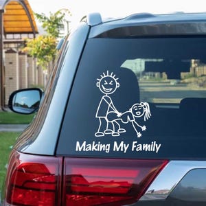 Puede incluir: Adhesivo de vinilo blanco para coche con figuras de palo en una pose sugerente. El texto "Making My Family" está debajo de las figuras. El adhesivo está pegado en la ventana trasera de un coche.