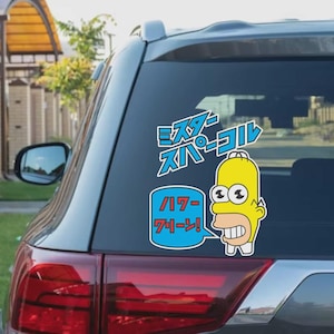 May include: A sticker featuring a yellow cartoon character with Japanese text above. The character is in a speech bubble with more Japanese text. The sticker is on a car window.