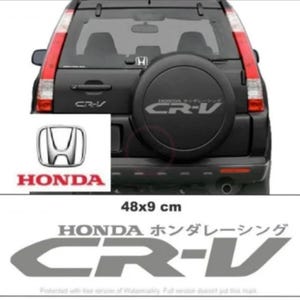Puede incluir: SUV Honda CR-V negro con una cubierta de neumático de repuesto con el logotipo Honda CR-V. Un rectángulo blanco muestra el logotipo y el texto de Honda. Debajo, una pegatina gris dice "HONDA ホンダレーシング CR-V", mide 48x9 cm.