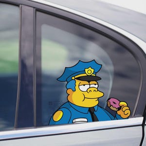 Puede incluir: Una calcomanía para ventana de coche con un oficial de policía de dibujos animados con uniforme y sombrero azules, sosteniendo una rosquilla glaseada rosa. El oficial tiene la piel amarilla y una expresión severa. La calcomanía está aplicada a una ventana de coche.