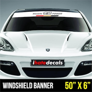 May include: White windshield banner with "MUGEN POWER" text and a red, gold, and black stripe. The banner is 50" x 6" and is displayed on a white car. The car has the "ihatedecals" logo on the front.