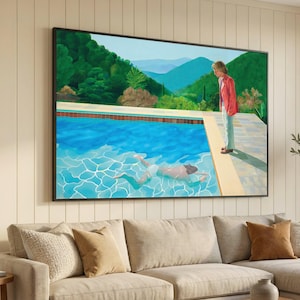May include: Large framed art print depicting a swimming pool scene with a person in the water and another standing poolside. The artwork features a vibrant blue pool, lush green hills, and a person in a red jacket.