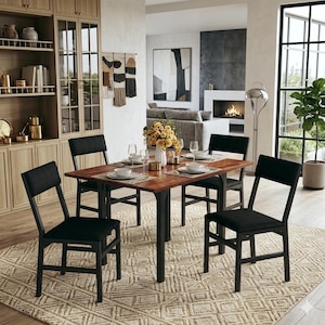 May include: A dining room set featuring a rectangular wooden table with black metal legs and four black upholstered chairs. The table is set with plates, glasses, and silverware. The room has a neutral color palette with a patterned rug.