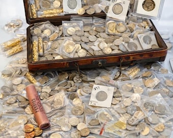 Könnte beinhalten: Eine Holzkiste, die mit einer Sammlung von Münzen überquillt, darunter Silbermünzen in Plastiktüten, Goldmünzen und eine Rolle Pennys. Einige Münzen befinden sich in Schutzhüllen. Die Kiste ist geöffnet und Münzen sind darum herum verstreut.