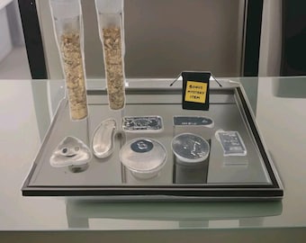 May include: A display of various collectibles, including two clear tubes filled with gold flakes, silver bars, and a black bag labeled "BONUS MYSTERY ITEM." Other items include a silver eight ball and a coin.