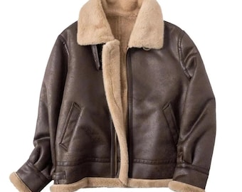 May include: A brown faux leather jacket with a beige faux fur collar and lining. The jacket has a zip-up front, two front pockets, and a buckled strap at the collar. The sleeves have a faux fur trim at the cuffs. A classic outerwear piece.