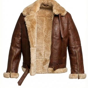 Puede incluir: Chaqueta de cuero marrón con forro y cuello de borrego. La chaqueta tiene cremallera frontal, bolsillos laterales y cinturón con hebilla en la cintura. Los puños también tienen ribete de borrego. Una prenda de abrigo clásica.