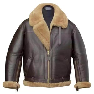 Puede incluir: Chaqueta bomber de cuero marrón con cuello y forro de borrego beige. La chaqueta tiene cremallera frontal, bolsillos laterales y cinturón en la cintura. Las mangas tienen cremalleras en los puños.