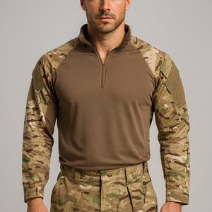 May include: A camouflage long-sleeved shirt and trousers. The shirt features a brown torso, camouflage sleeves, and a quarter-zip collar. The trousers are also in a camouflage pattern. The outfit is suitable for outdoor pursuits.