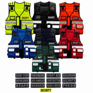 Op de afbeelding: Een collectie van zeven utility-vesten met meerdere zakken in neongeel, zwart, oranje, blauw, marineblauw, rood en donkergroen. Elk vest is voorzien van reflecterende strips en een patch met SECURITY of PARAMEDIC, plus verwisselbare tekstlabels.
