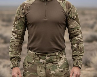 Puede incluir: Una persona con una camisa de combate de camuflaje con torso marrón y mangas largas, combinada con pantalones de camuflaje a juego. El atuendo está diseñado para actividades al aire libre y uso táctico.