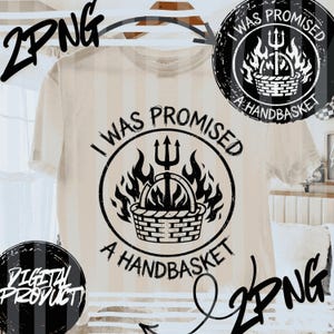 Puede incluir: Camiseta color crema con un gráfico negro. El gráfico presenta un tridente sobre una cesta en llamas, rodeado por el texto "I WAS PROMISED A HANDBASKET". El diseño también está en una insignia circular.