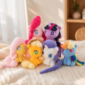 May include: A collection of six plush pony toys featuring vibrant colours including pink, yellow, orange, white, purple, and blue. Each soft toy has large embroidered eyes, a textured mane, and a tail, representing various characters with distinct hair colours.