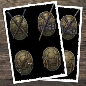 May include: Two prints featuring illustrations of Teenage Mutant Ninja Turtle shells with different weapons. The shells are brown and textured, with weapons including swords, a bo staff, and nunchucks. The prints are on a black background.