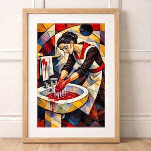 May include: Framed art print depicting a woman washing her hands in a sink filled with red liquid. She wears a white apron with red trim and stands before a stained-glass window. The artwork is framed in a light wood.