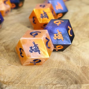 Peut inclure: Un ensemble de dés polyédriques présentant un mélange de couleurs orange marbré et violet profond. Les dés ont des bords tranchants et sont gravés de chiffres bleu foncé ou orange vif ainsi que de symboles complexes en police gothique.