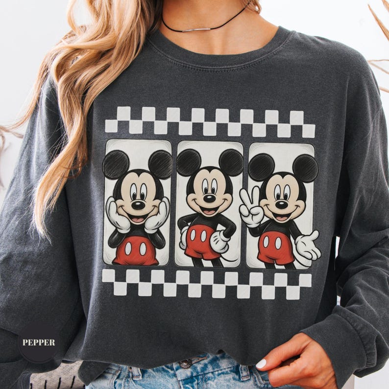 Puede incluir: Sudadera gris oscuro con tres im&aacute;genes de Mickey Mouse seguidas, cada una en una pose diferente. Las im&aacute;genes est&aacute;n enmarcadas con un patr&oacute;n de cuadros blancos y negros. La palabra "PEPPER" est&aacute; impresa en la parte inferior izquierda.