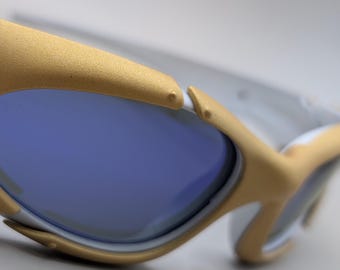 Oakley zonnebril in plaatstijl – gouden montuur met blauwe lenzen, Y2K Sport design